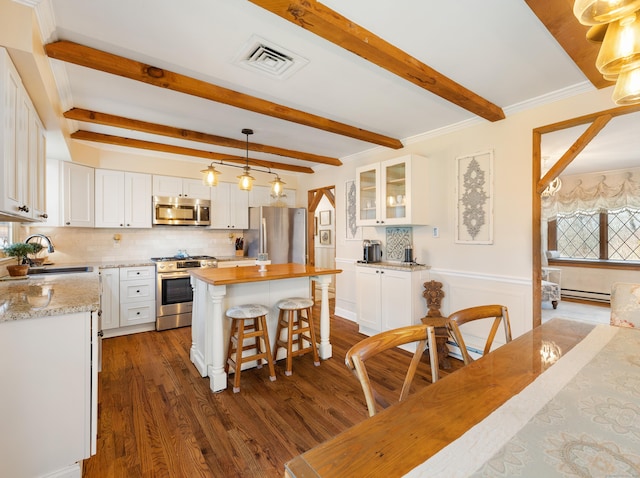 kitchen featuring visible vents, a sink, a kitchen island, appliances with stainless steel finishes, and white cabinetry