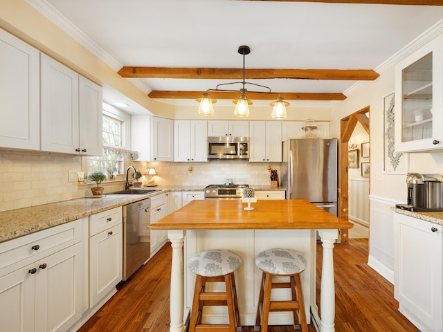 kitchen with a sink, dark wood-type flooring, wood counters, appliances with stainless steel finishes, and white cabinetry
