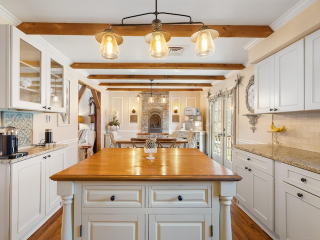 kitchen featuring backsplash, a center island, dark wood-style floors, and white cabinets