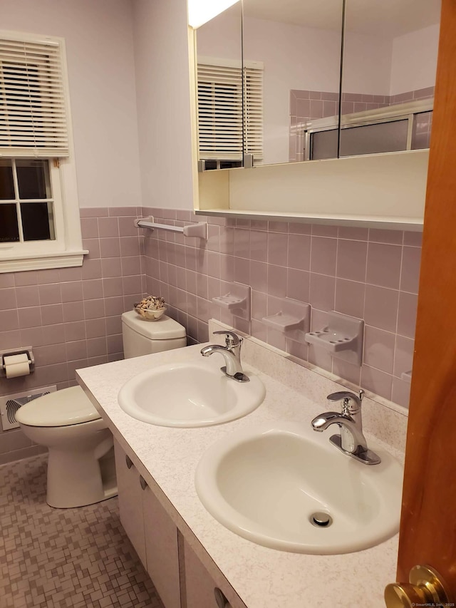 bathroom with an enclosed shower, toilet, visible vents, and a sink