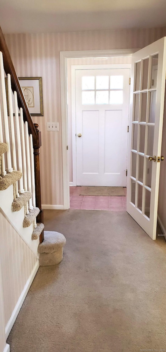 entrance foyer featuring stairway, carpet floors, baseboards, and wallpapered walls