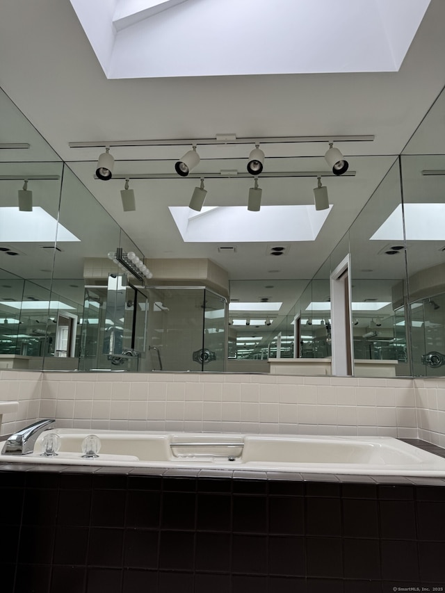 bathroom featuring a sink, a shower stall, and a garden tub