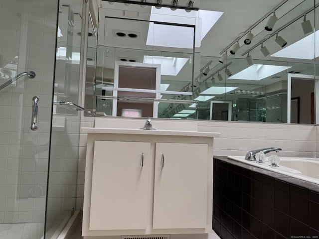 full bathroom with vanity, a bath, and a shower stall