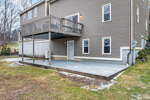 back of property with a wooden deck and a patio area