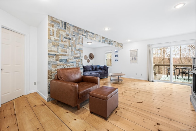 living room featuring recessed lighting, baseboards, and light wood-type flooring