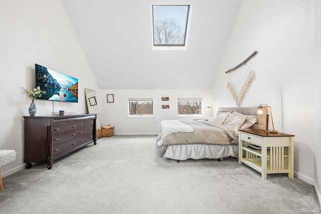 carpeted bedroom with high vaulted ceiling, a skylight, and baseboards