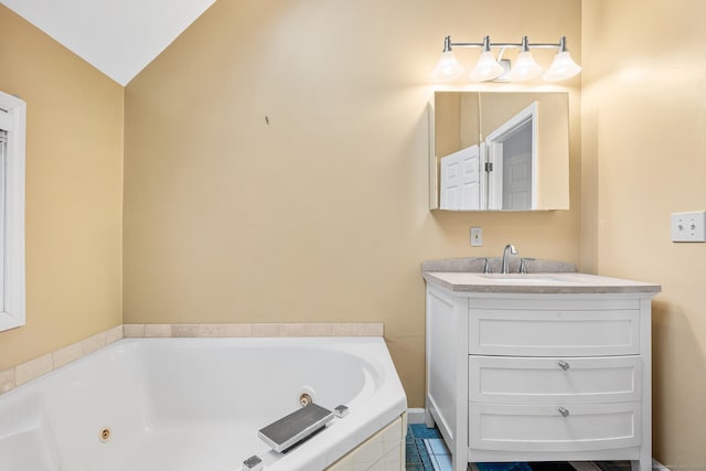 bathroom with vaulted ceiling, vanity, and a tub with jets