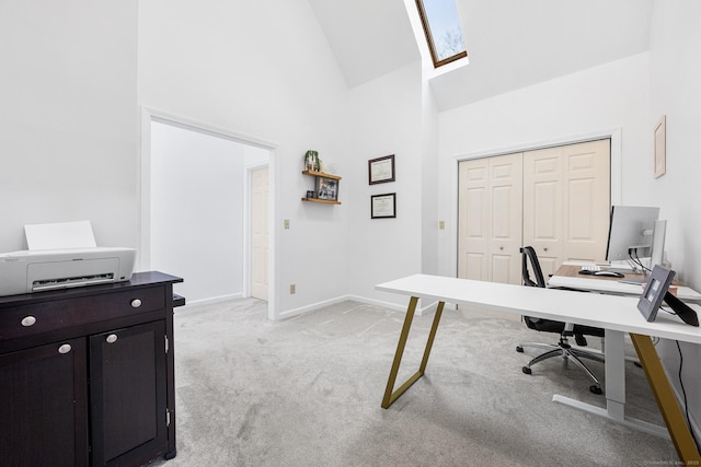 home office with baseboards, a skylight, high vaulted ceiling, and light carpet