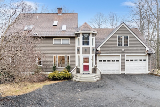 view of front of property featuring driveway, a chimney, and roof with shingles