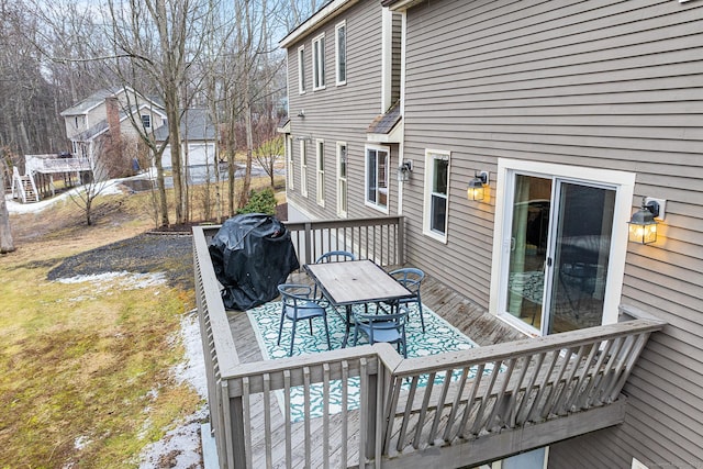 wooden terrace featuring outdoor dining area and a grill