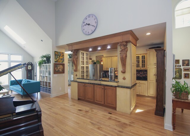 6 Rogers Dr, Stonington, CT 06355 - kitchen featuring high vaulted ceiling, light wood-type flooring, freestanding refrigerator, glass insert cabinets, and a skylight