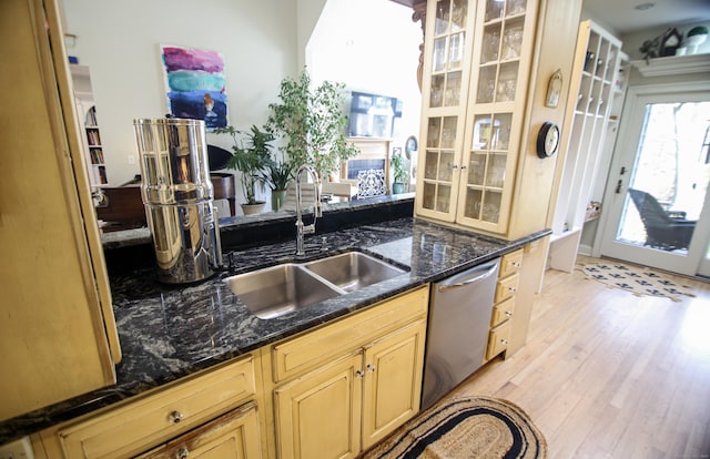 6 Rogers Dr, Stonington, CT 06355 - kitchen featuring stainless steel dishwasher, a sink, light wood finished floors, glass insert cabinets, and dark stone countertops