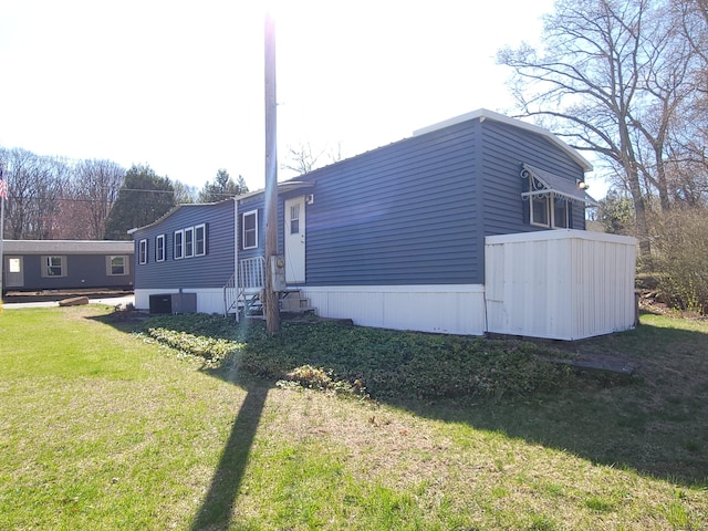 view of property exterior with central air condition unit and a yard