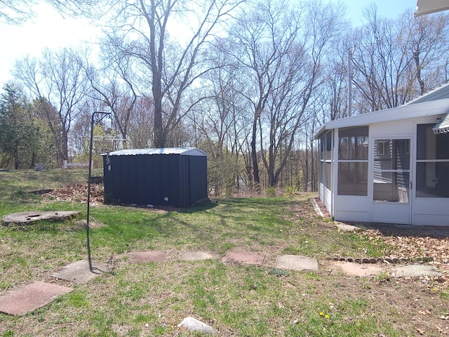 view of yard featuring an outdoor structure and a sunroom