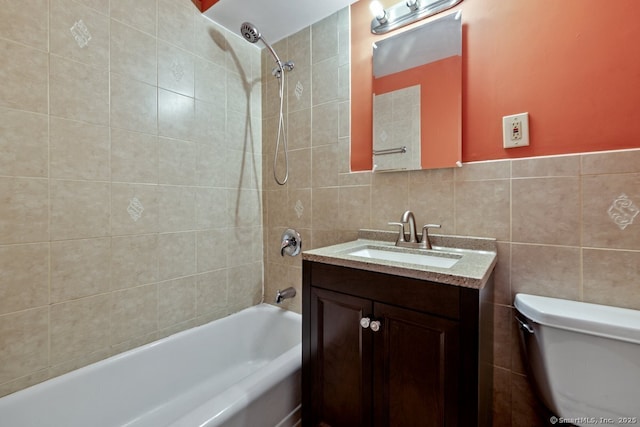 bathroom with toilet, vanity,  shower combination, and tile walls