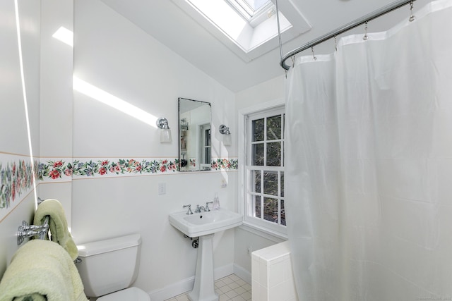 full bathroom with toilet, vaulted ceiling with skylight, a shower with shower curtain, and a wealth of natural light