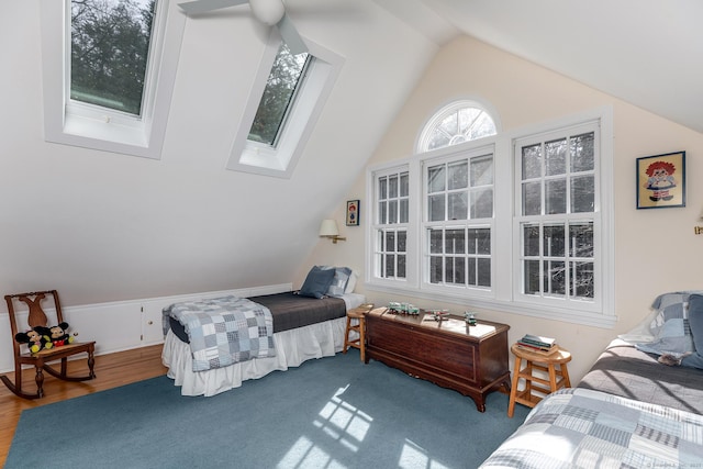 bedroom featuring wood finished floors and vaulted ceiling with skylight