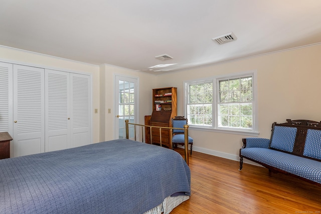bedroom with baseboards, visible vents, light wood-style floors, and multiple windows