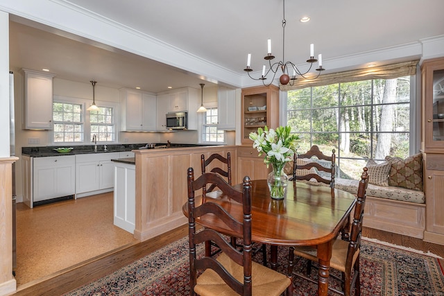 dining room with light wood finished floors, recessed lighting, and a notable chandelier