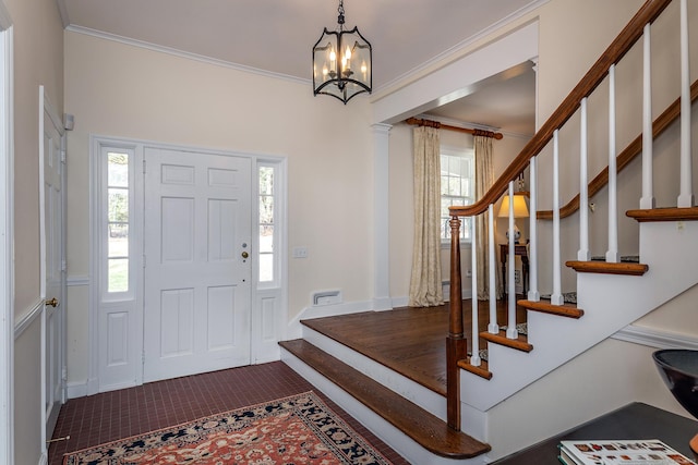 tiled foyer featuring stairway, a notable chandelier, and plenty of natural light
