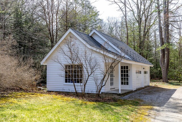 view of side of home featuring a yard and gravel driveway