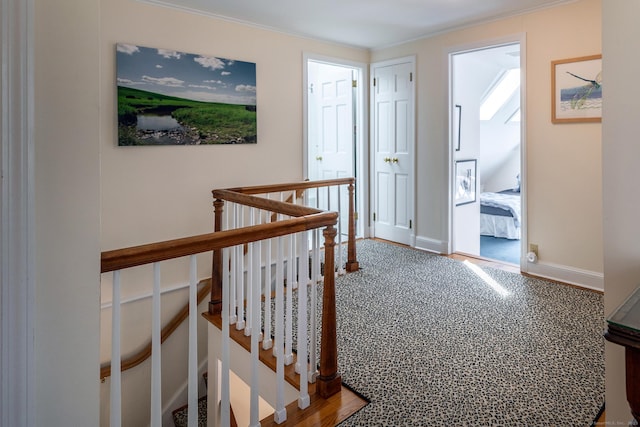 hall featuring baseboards and an upstairs landing