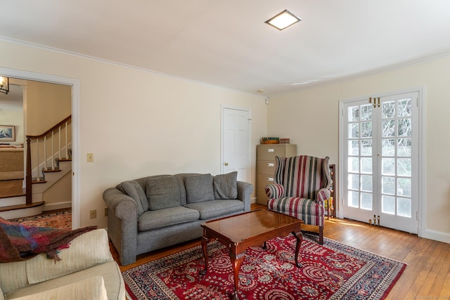 living room with hardwood / wood-style floors, stairs, ornamental molding, and plenty of natural light