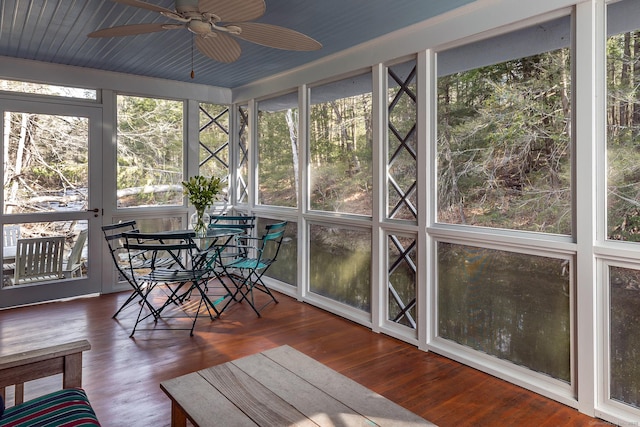 sunroom / solarium featuring outdoor dining space and ceiling fan