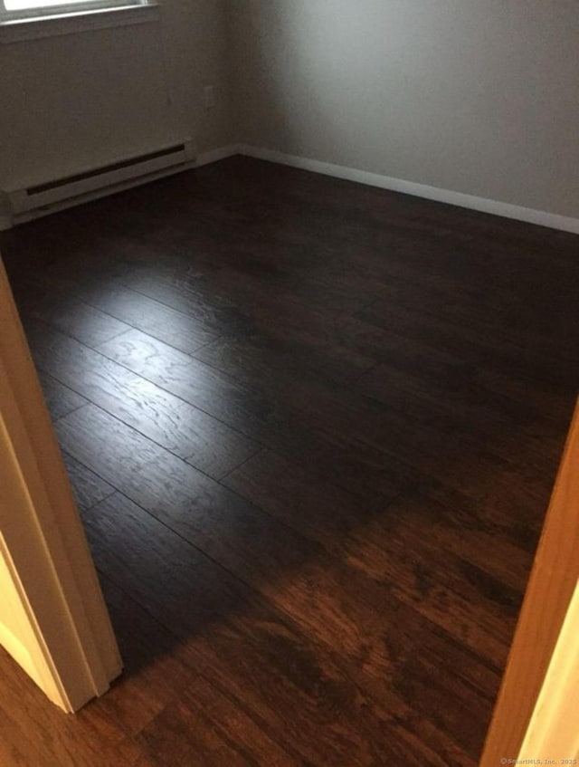 51 Mortimer St Apt 9, Torrington, CT 06790 - spare room with a baseboard heating unit, baseboards, and dark wood-style floors