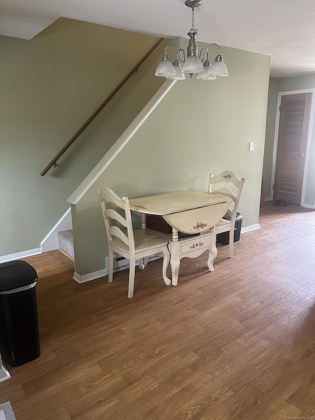 51 Mortimer St Apt 9, Torrington, CT 06790 - dining room featuring baseboards, a notable chandelier, wood finished floors, and stairs