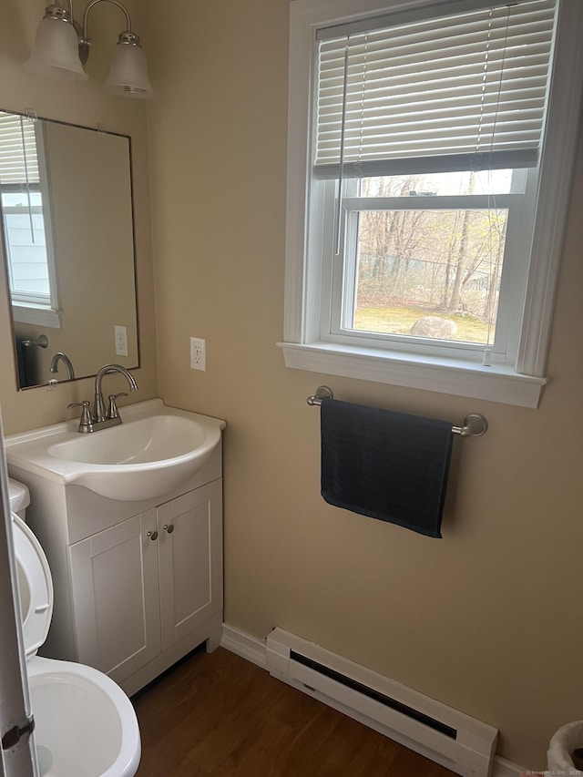 51 Mortimer St Apt 9, Torrington, CT 06790 - half bathroom with toilet, baseboards, wood finished floors, vanity, and a baseboard radiator
