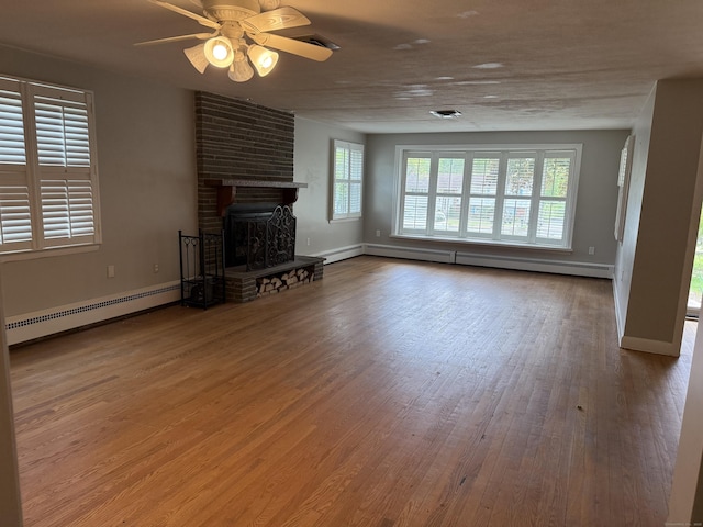 278 Dudley Town Rd, Windsor, CT 06095 - unfurnished living room featuring baseboard heating, wood finished floors, a brick fireplace, and plenty of natural light