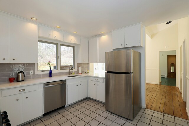 45 Wayside Ln, Redding, CT 06896 - kitchen featuring stainless steel appliances, a sink, light countertops, backsplash, and white cabinets