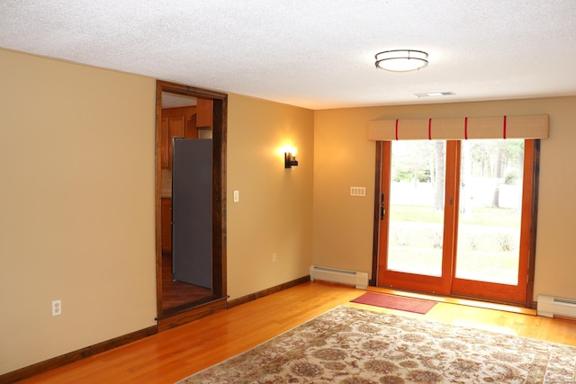 1 Sunrise Cir, Enfield, CT 06082 - doorway featuring visible vents, baseboards, a textured ceiling, light wood-style flooring, and a baseboard heating unit
