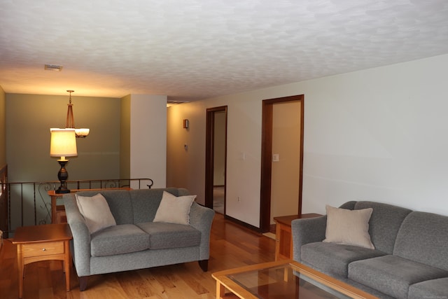 1 Sunrise Cir, Enfield, CT 06082 - living area featuring a textured ceiling, wood finished floors, and visible vents