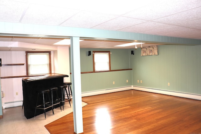 1 Sunrise Cir, Enfield, CT 06082 - basement featuring a bar, a baseboard heating unit, and wood finished floors