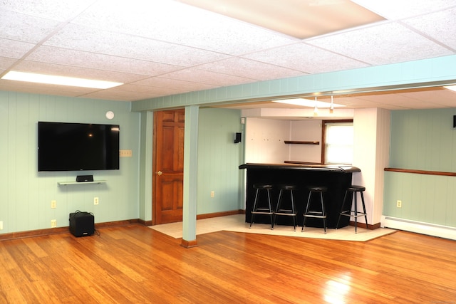 1 Sunrise Cir, Enfield, CT 06082 - living area featuring a drop ceiling, wood finished floors, a baseboard heating unit, baseboards, and indoor bar