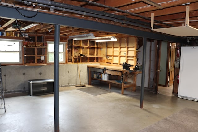 1 Sunrise Cir, Enfield, CT 06082 - basement featuring freestanding refrigerator and a workshop area
