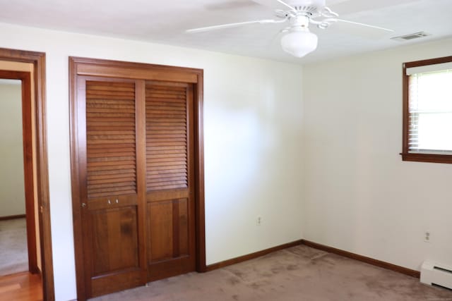 1 Sunrise Cir, Enfield, CT 06082 - unfurnished bedroom featuring a baseboard heating unit, light colored carpet, and ceiling fan