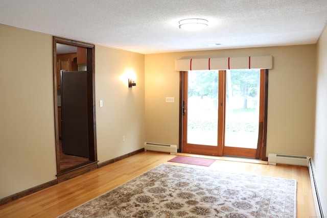 1 Sunrise Cir, Enfield, CT 06082 - unfurnished room featuring a baseboard radiator, light wood-type flooring, and a textured ceiling
