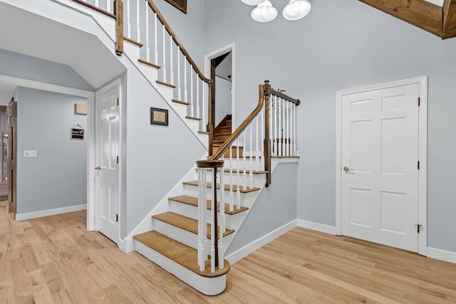 15 Briarwood Dr, Guilford, CT 06437 - stairway featuring wood finished floors, high vaulted ceiling, and a chandelier