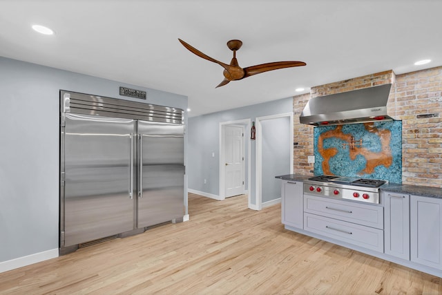 15 Briarwood Dr, Guilford, CT 06437 - kitchen with appliances with stainless steel finishes, wall chimney range hood, a ceiling fan, light wood-style flooring, and recessed lighting