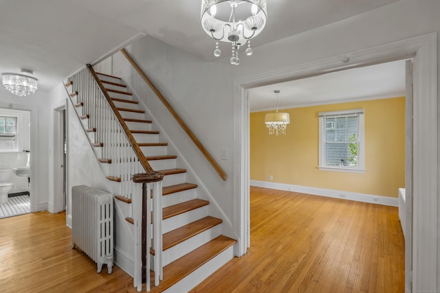 25 S Highland St, West Hartford, CT 06119 - stairs featuring a chandelier, radiator heating unit, hardwood / wood-style flooring, and plenty of natural light