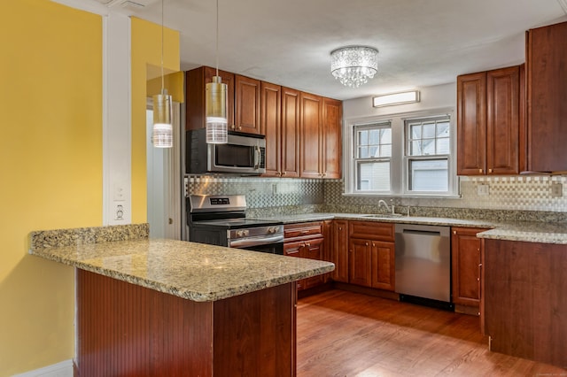 25 S Highland St, West Hartford, CT 06119 - kitchen with stainless steel appliances, a peninsula, backsplash, light wood-type flooring, and a sink