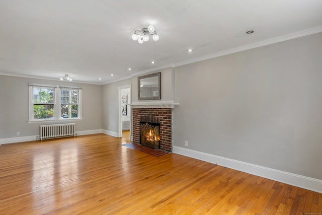 25 S Highland St, West Hartford, CT 06119 - unfurnished living room featuring radiator, light wood-style floors, crown molding, baseboards, and a brick fireplace