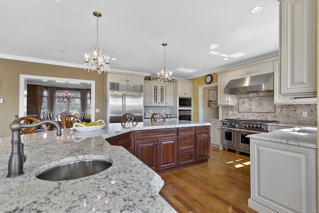 22 Nature Ln, Shelton, CT 06484 - kitchen featuring ventilation hood, a chandelier, built in appliances, cream cabinetry, and crown molding