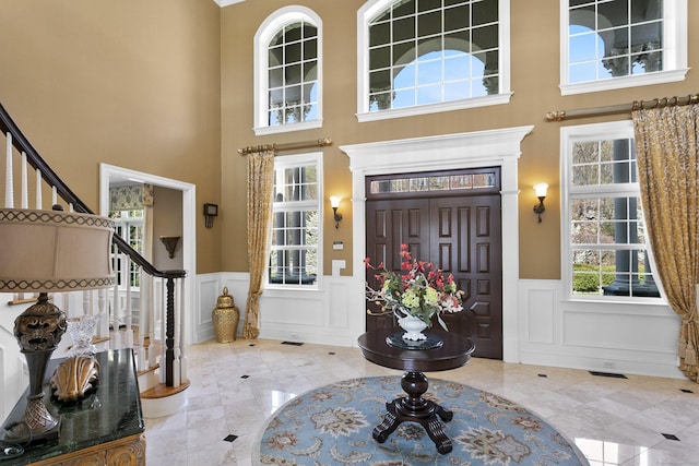 22 Nature Ln, Shelton, CT 06484 - tiled foyer entrance featuring a decorative wall, stairway, a wainscoted wall, and a high ceiling