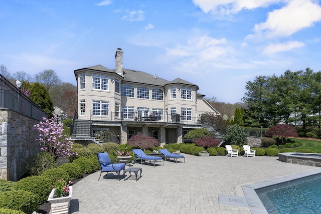 22 Nature Ln, Shelton, CT 06484 - back of property with stairs, a patio area, a chimney, an outdoor pool, and an in-ground hot tub