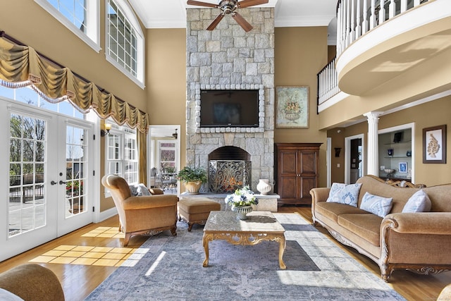 22 Nature Ln, Shelton, CT 06484 - living room featuring a stone fireplace, crown molding, ceiling fan, french doors, and plenty of natural light
