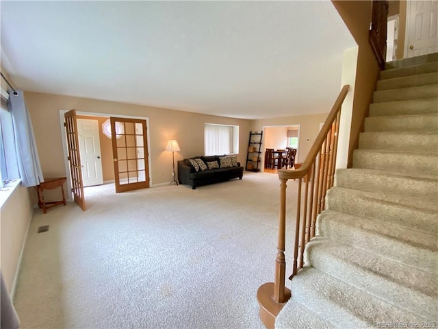 stairs featuring baseboards, french doors, visible vents, and carpet flooring